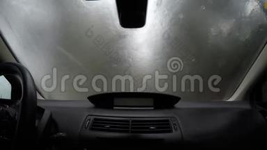一辆汽车的挡风玻璃被<strong>阻挡</strong>在道路视野之外的强力雨滴击中。